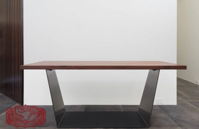 custom walnut table with thin metal base.
